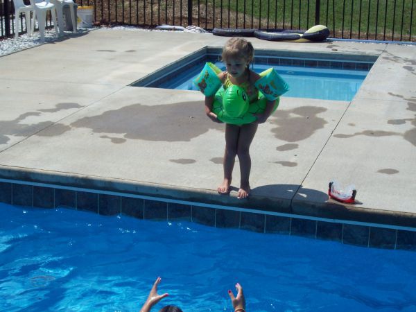 Girl standing next to pool - Should I buy a pool?