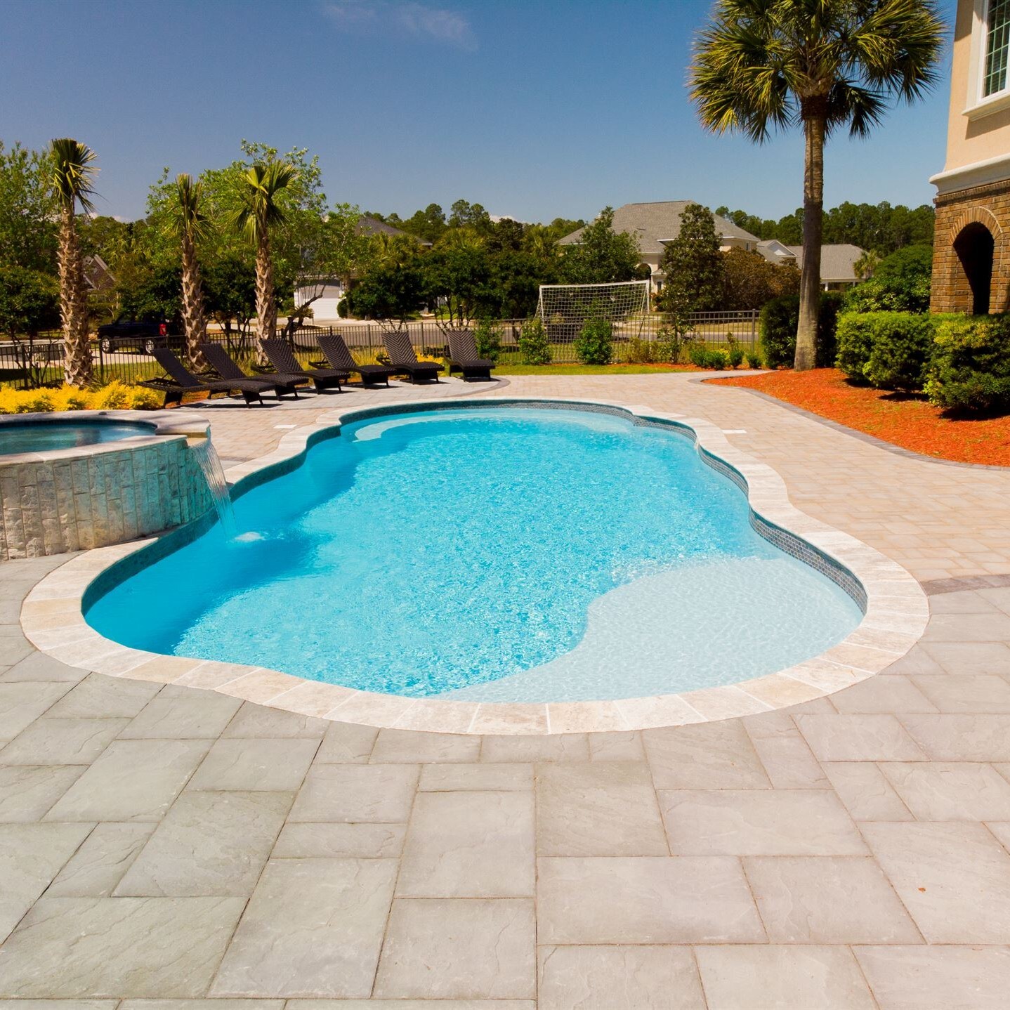 015. River Pools C40 + RS08 with spillway in Caribbean Sparkle with concrete paver patio and natural stone coping-1