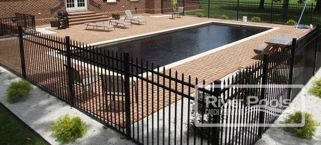 Brick pool patio around black fiberglass pool