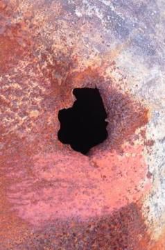 Rust (corrosion) formed a hole on a metal wall panel in vinyl liner pool