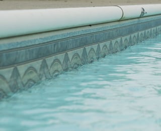 White aluminum C-channel coping on a vinyl liner pool