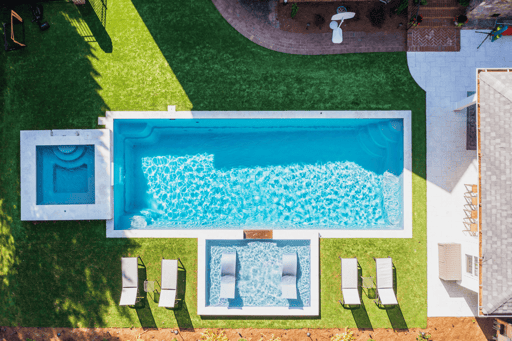 Aerial shot. R40 rectangle pool by River Pools with a square spillover spa and tanning ledge add-on.