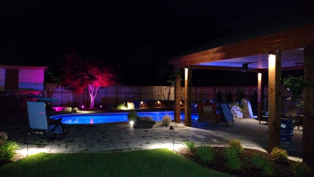 Pool and patio with multicolored lights, at night