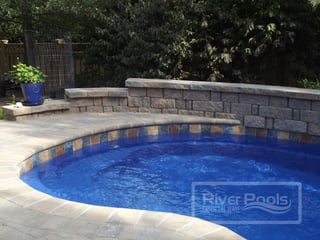 Earthy stone tile along the waterline of our fiberglass pool