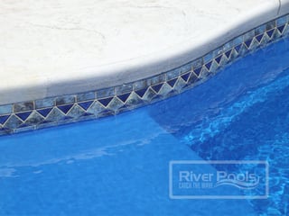 Blue stone mosaic tile along waterline of our fiberglass pool