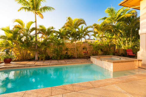 Concrete pool with spa in backyard