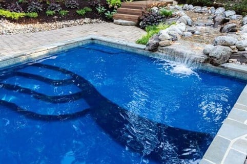 blue fiberglass pool with waterfall