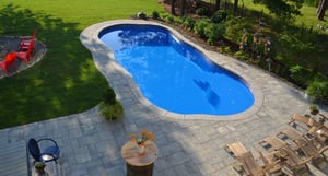 lighter blue C Series pool with tan stone patio