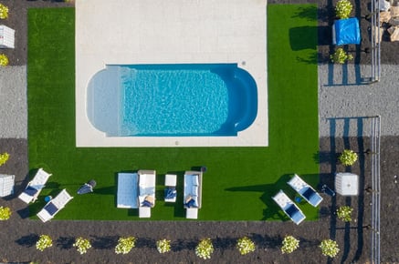 Letecký záběr na sklolaminátový bazén v římském designu.