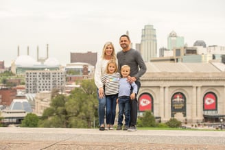River Pools Kansas City Owners and Operators Jeff and Angela Sebek stand with their children in front of Arrowhead Stadium. 