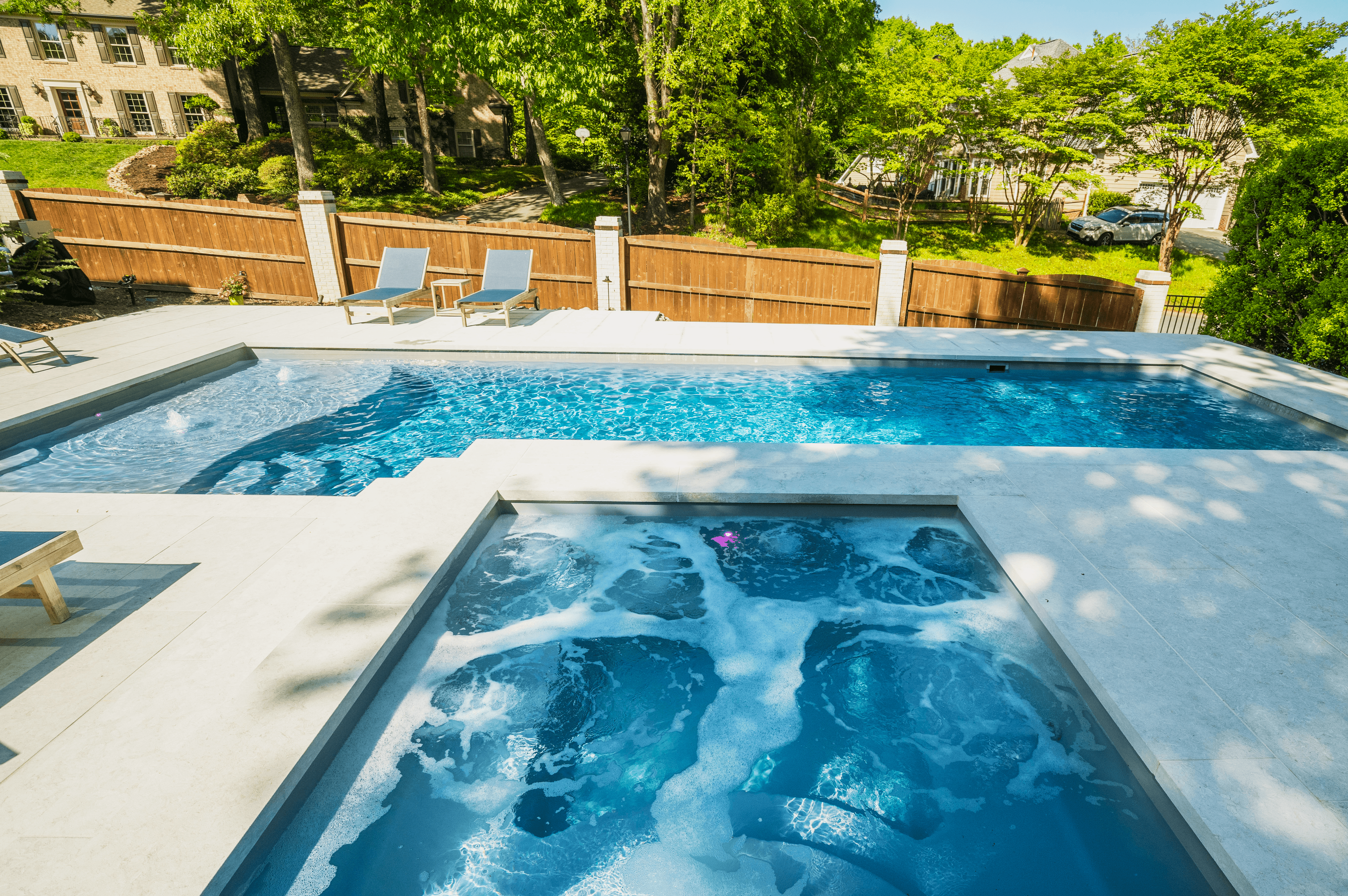 River Pools D40 + SS08 in Granite Gray with cascades, bubblers, and natural stone patio and coping 8