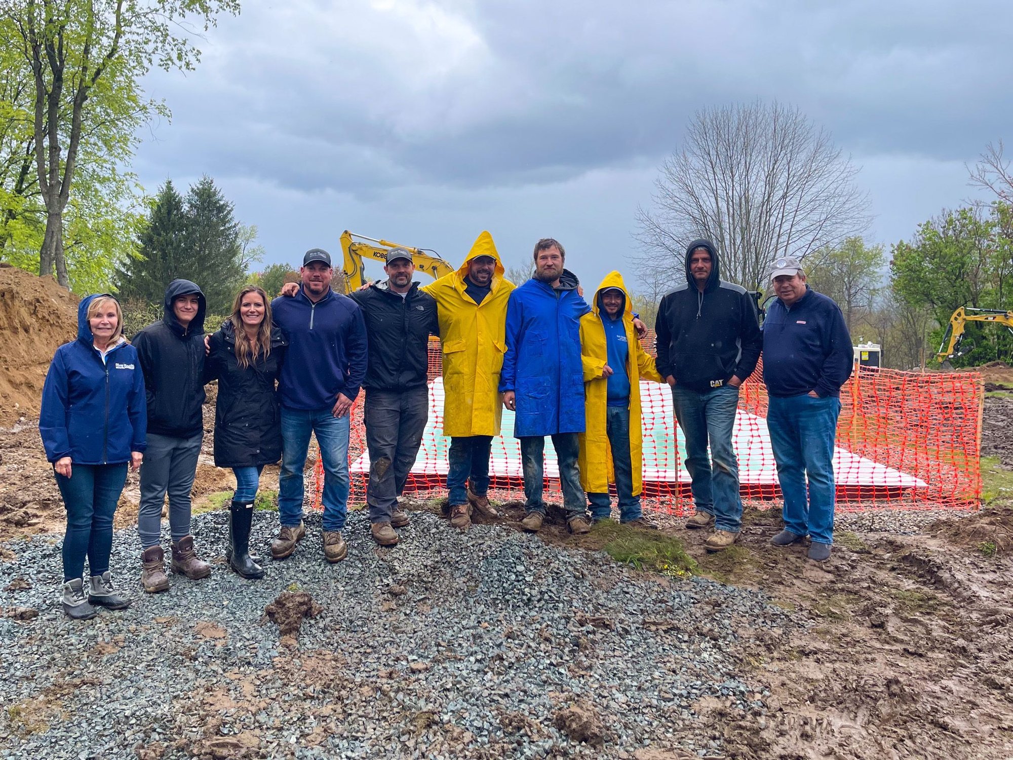 Team members from River Pools Capital Region standing together on a fiberglass pool installation site in Clifton Park, NY