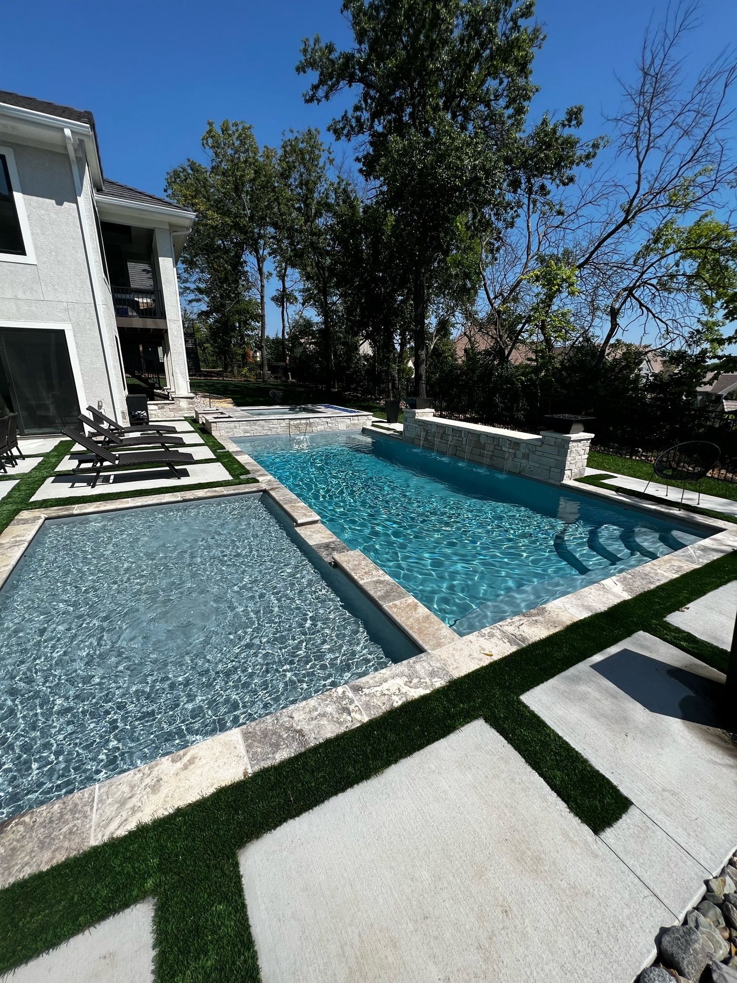 Overland Park fiberglass pool with shallow tanning ledge, bubblers, and a modern geometric layout.