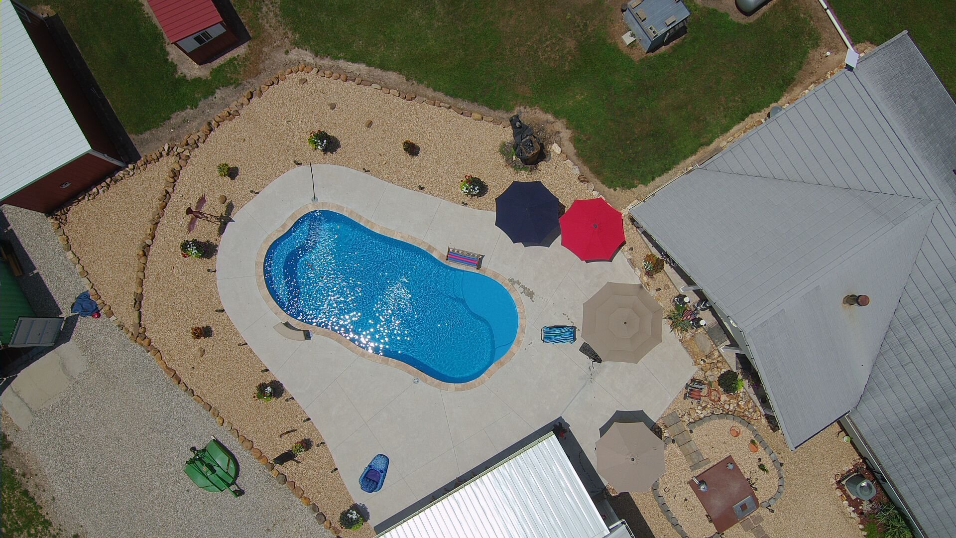 Custom fiberglass pool installation in Branson, MO with tiered landscaping and dining area