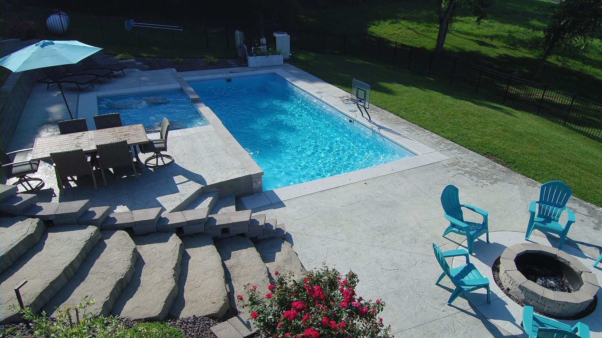 Rectangular-shaped fiberglass pool in Republic, MO with elevated spa, lounge chairs, and open yard design