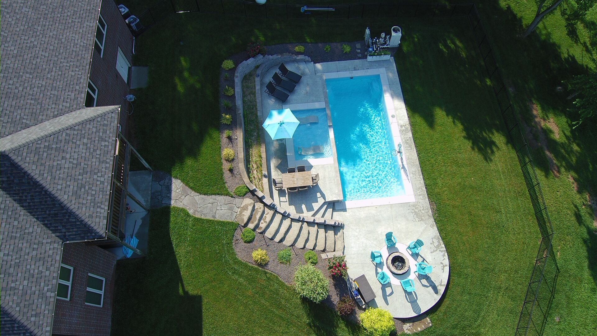 Backyard fiberglass pool installation in Rogersville, MO with stamped concrete and scenic view
