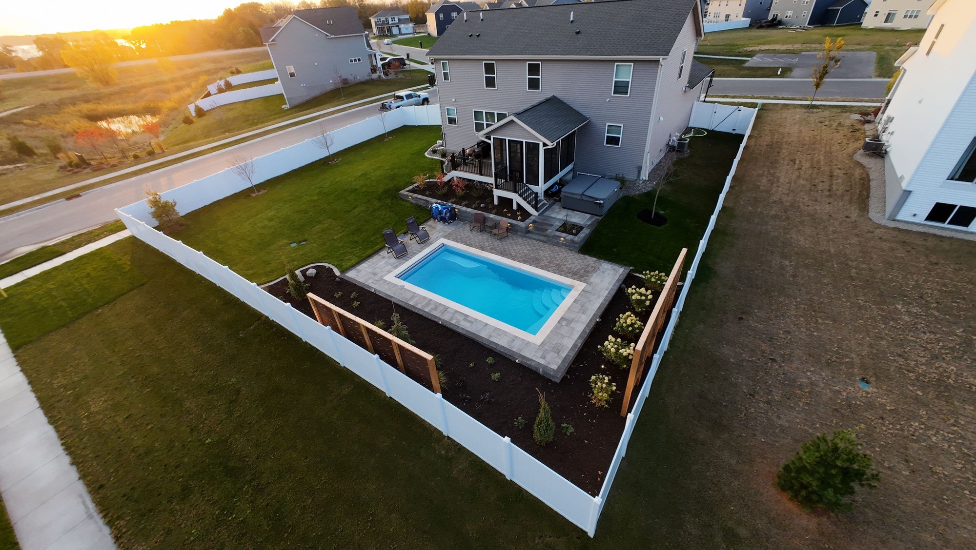 Small backyard with a rectangular inground fiberglass pool from River Pools, installed by River Pools of Red Wing near Minneapolis, MN, surrounded by paver patio and privacy fencing.