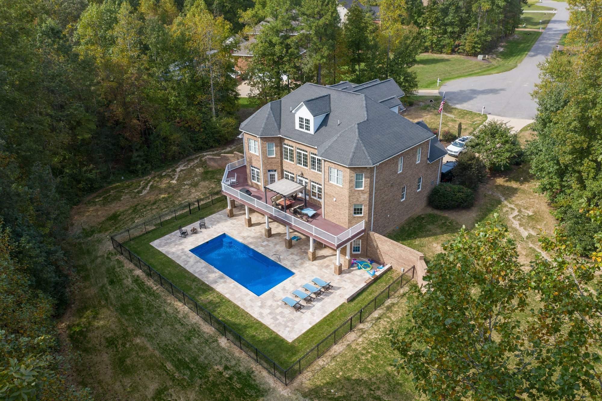Modern inground fiberglass pool in Northern Virginia with attached spa, pergola, and large travertine patio—designed for entertainment and relaxation.