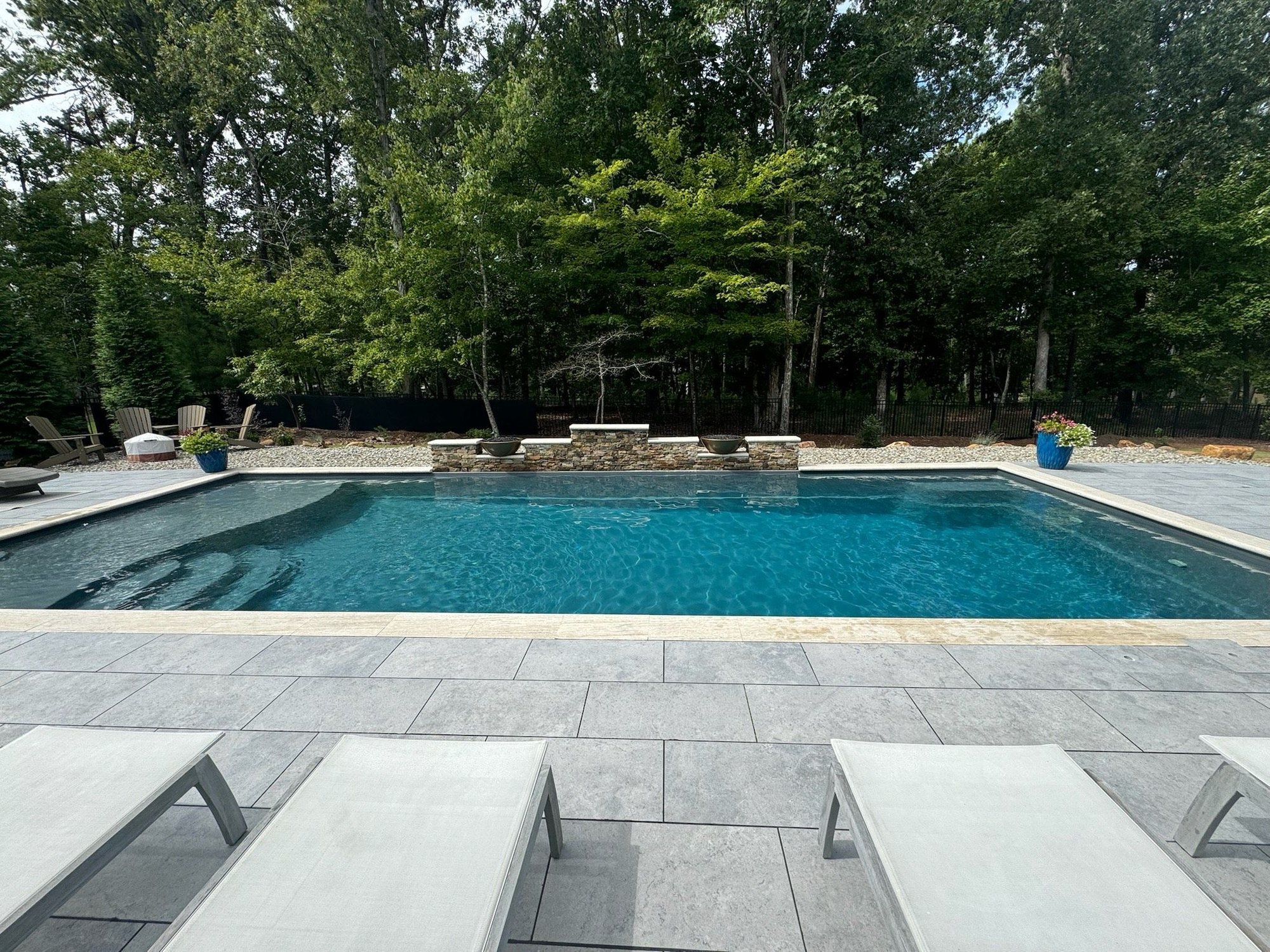 Modern fiberglass pool with clean lines and privacy landscaping installed in Burlington, NC.