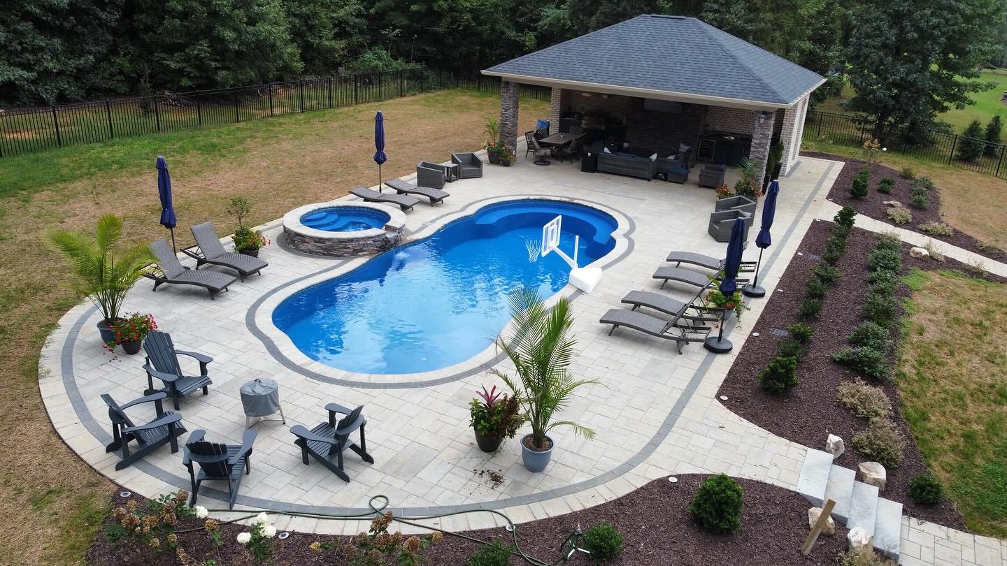 Freeform fiberglass pool with spa and basketball hoop installed for a family in High Point, NC.