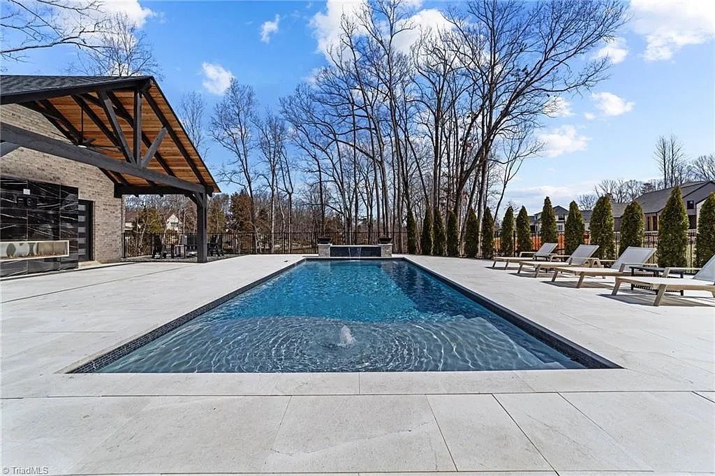Sleek rectangular fiberglass pool with natural stone surround installed in Kernersville, NC.