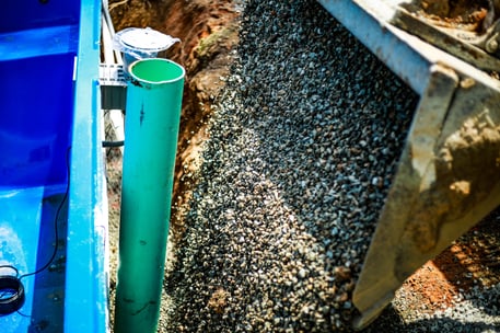 pouring-crushed-stone-next-to-fiberglass-pool