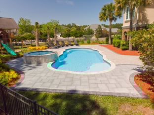 River Pools C40 + RS08 with spillway in Caribbean Sparkle with concrete paver patio and natural stone coping
