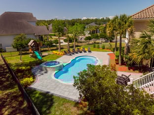 River Pools C40 + RS08 with spillway in Caribbean Sparkle with concrete paver patio and natural stone coping