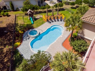 River Pools C40 + RS08 with spillway in Caribbean Sparkle with concrete paver patio and natural stone coping
