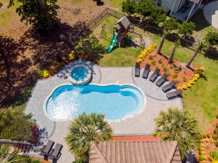 River Pools C40 + RS08 with spillway in Caribbean Sparkle with concrete paver patio and natural stone coping