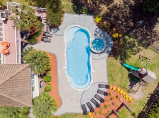 River Pools C40 + RS08 with spillway in Caribbean Sparkle with concrete paver patio and natural stone coping