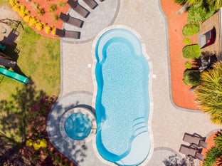 River Pools C40 + RS08 with spillway in Caribbean Sparkle with concrete paver patio and natural stone coping