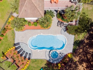 River Pools C40 + RS08 with spillway in Caribbean Sparkle with concrete paver patio and natural stone coping