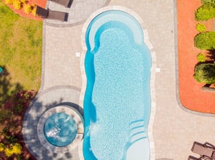 River Pools C40 + RS08 with spillway in Caribbean Sparkle with concrete paver patio and natural stone coping