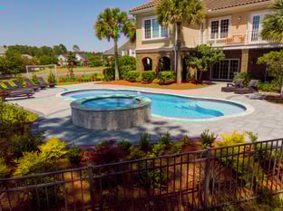 River Pools C40 + RS08 with spillway in Caribbean Sparkle with concrete paver patio and natural stone coping