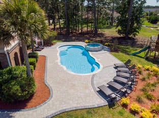 River Pools C40 + RS08 with spillway in Caribbean Sparkle with concrete paver patio and natural stone coping