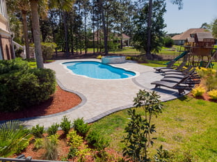 River Pools C40 + RS08 with spillway in Caribbean Sparkle with concrete paver patio and natural stone coping