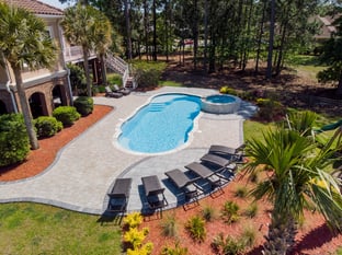 River Pools C40 + RS08 with spillway in Caribbean Sparkle with concrete paver patio and natural stone coping