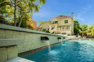 River Pools D40 + SS08 in Diamond with cascades, bubblers, and natural stone patio and coping