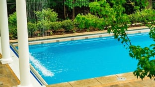  G36 fiberglass pool in California Shimmer color with a waterfall feature