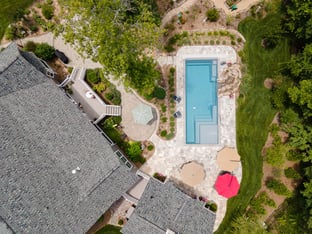 River Pools M35 in Diamond color with a cascade, natural stone patio, and concrete paver coping