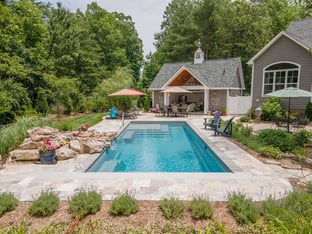 River Pools M35 in Diamond color with a cascade, natural stone patio, and concrete paver coping