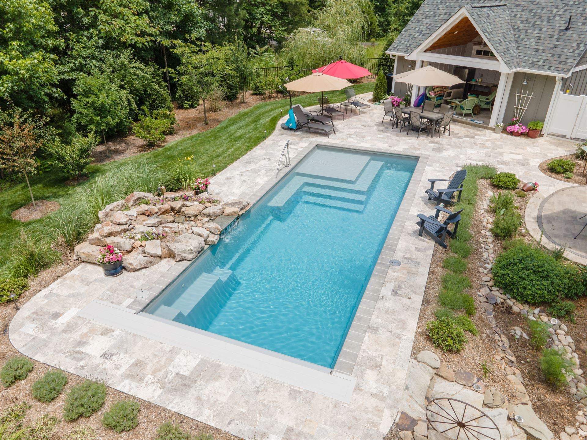 017. River Pools M35 in Granite Gray with a cascade, natural stone patio, and concrete paver coping