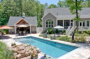 River Pools M35 in Diamond color with a cascade, natural stone patio, and concrete paver coping