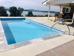 R24 pool in Caribbean with travertine coping and brushed concrete decking