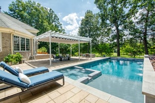 River Pools X36 in Diamond color with cascade, concrete paver patio, and natural stone coping
