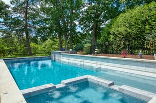 River Pools X36 in Diamond color with cascade, concrete paver patio, and natural stone coping