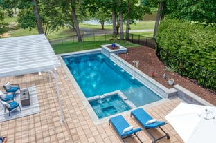 River Pools X36 in Diamond color with cascade, concrete paver patio, and natural stone coping