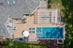 River Pools X36 in Diamond color with cascade, concrete paver patio, and natural stone coping