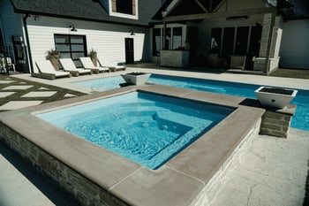 Modern fiberglass spa from River Pools installed in a custom backyard patio